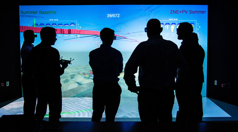 People standing in front of a large screen