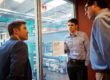 Three men looking out over a laboratory