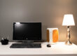 A desk with a computer and lamp