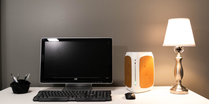 A desk with a computer and lamp