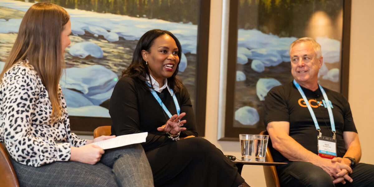 Akilah and Katie on Panel Three people sit in chairs talking in front of an audience
