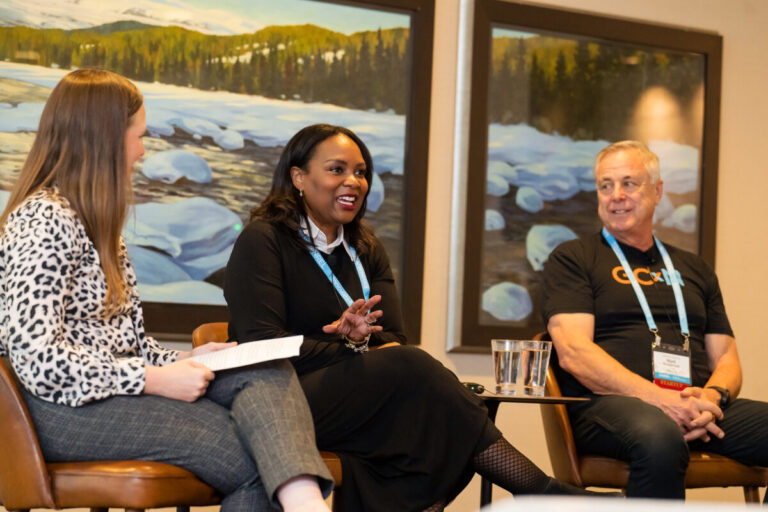 Akilah and Katie on Panel Three people sit in chairs talking in front of an audience