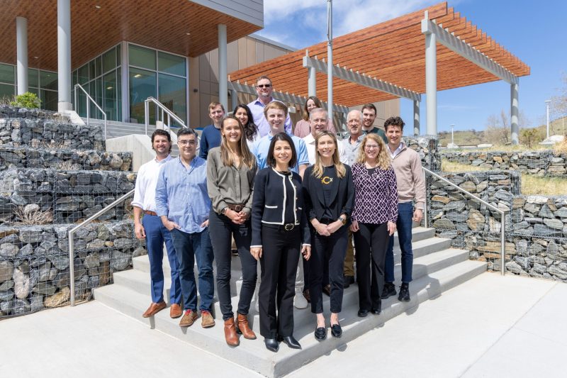 GCxN Cohort 7 Onboarding Fifteen people stand on steps outside a building and smile for the camera.